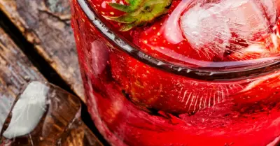 A southern sweet tea jam drink in a glass garnished with strawberries