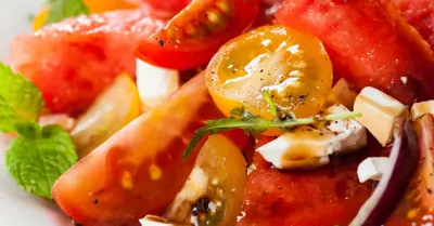 An heirloom tomato and watermelon salad in a white plate