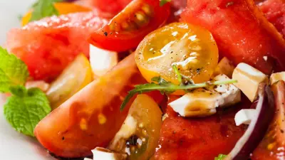 An heirloom tomato and watermelon salad in a white plate