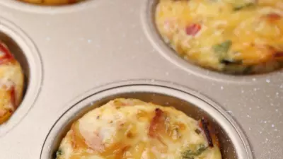 a muffin tin with grilled eggs in it