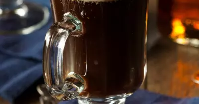 A kentucky coffee drink in a glass mug topped with whipped cream.