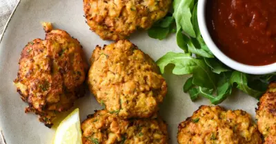 A crab appetizer recipe of crab cakes on a plate with cocktail saucce.
