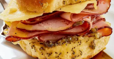 A hawaiian roll breakfast slider with ham and cheese on a plate.